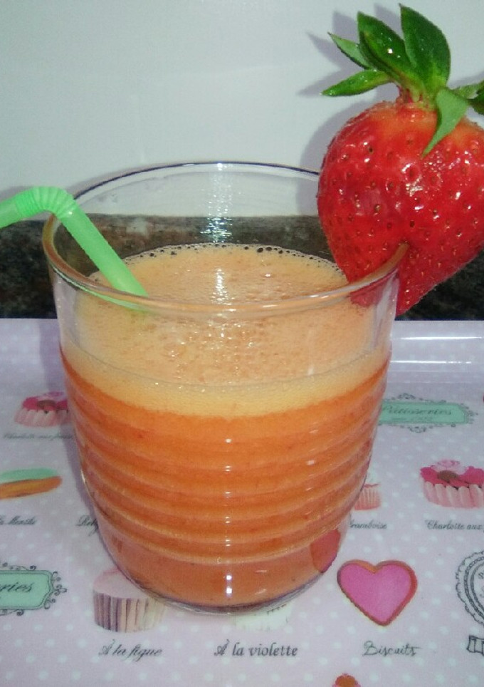 Una foto de Zumo de naranja y fresas