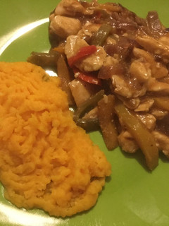 Una foto de Pollo con pimentones en salsa acompañado de puré naranjo