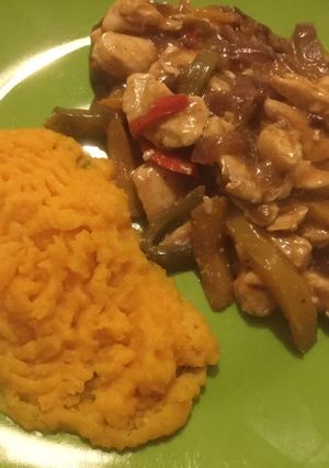 Una foto de Pollo con pimentones en salsa acompañado de puré naranjo