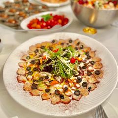 A picture of Octopus Carpaccio in extra virgin oil oil and paprika powder.