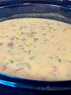 A picture of Corn chowder with ham or bacon.