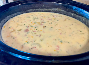A picture of Corn chowder with ham or bacon.