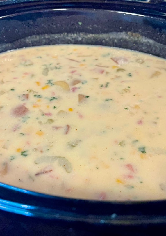 A picture of Corn chowder with ham or bacon.
