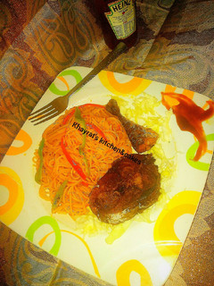 A picture of Jollof spaghetti with fried fish.