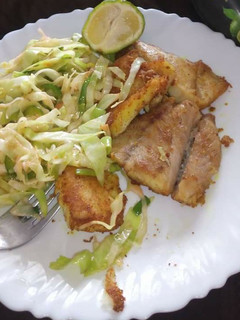 A picture of Fried fish fillet and fries cabbages.