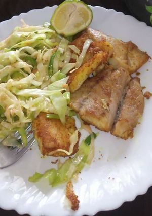 A picture of Fried fish fillet and fries cabbages.