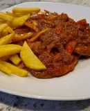 Filetes de cerdo en salsa de tomate y pimientos con patatas