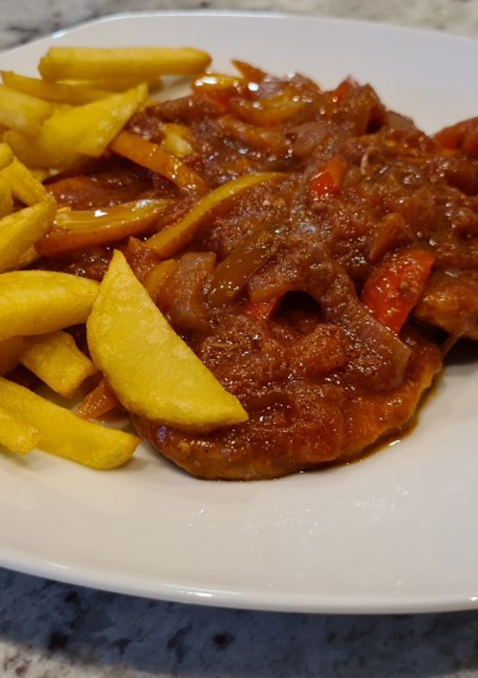 Una foto de Filetes de cerdo en salsa de tomate y pimientos con patatas