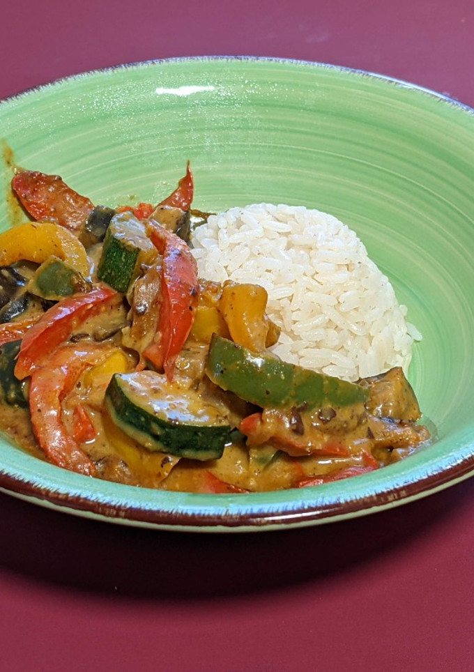 Una foto de Plato vegano: verduras en salsa satay con arroz