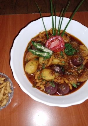 A picture of Punjabi Potatoes, onions pakoras curry🥔🍅🧅.