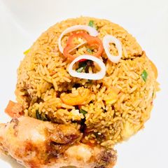 A picture of Brown veggie rice with pan seared chicken.