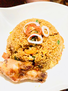 A picture of Brown veggie rice with pan seared chicken.