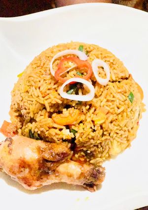 A picture of Brown veggie rice with pan seared chicken.