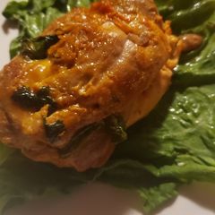 A picture of Stuff chicken with mozzarella and spinach.