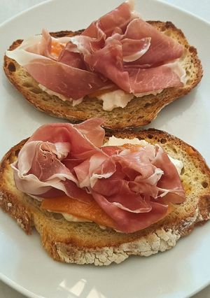A picture of Bruschetta with burrata melon and prosciutto San Daniele.