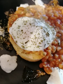 A picture of Poached egg, spicy baked beans on toast, marmalade and yoghurt.