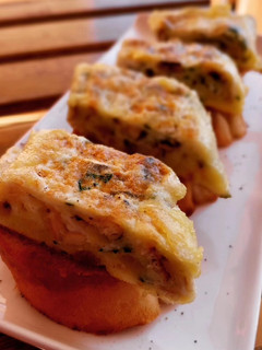 Una foto de Pincho de tortilla de boquerones y ajo asado