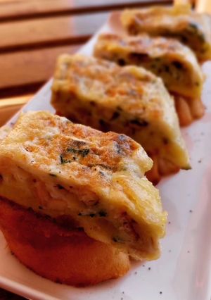 Una foto de Pincho de tortilla de boquerones y ajo asado