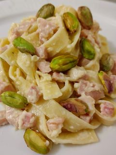Una foto de Nidos salteados con crema de queso, chopped y pistachos