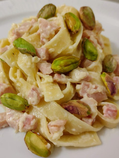 Una foto de Nidos salteados con crema de queso, chopped y pistachos