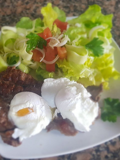 Una foto de Huevos escalfados con bife a la plancha y ensalada