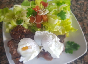 Una foto de Huevos escalfados con bife a la plancha y ensalada