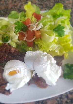 Una foto de Huevos escalfados con bife a la plancha y ensalada