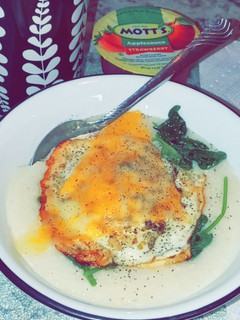 A picture of Grits bowl W/ Fried egg & Spinach.