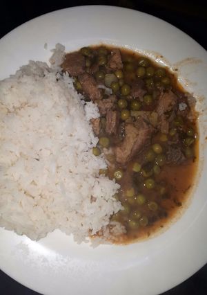 A picture of Rice served with peas stew.