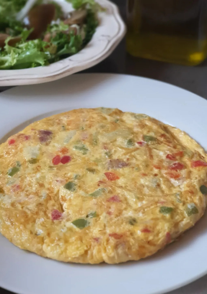Una foto de Tortilla paisana con tacos de jamón y patatas paja