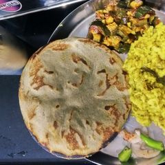A picture of Bajra no rotlo,lasaniya ringada nu shaak,khichadi upar ghee,chaas,onion,marcha.. kathiyawadi dinner.