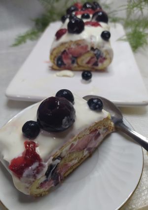 Una foto de Arrollado Con Crema De Queso Y Frutos Rojos / Postre Tronco Navideño De Verano