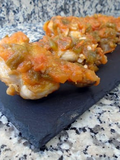 Una foto de Alitas de pollo con tomate y pimientos verdes