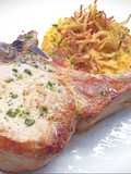 Braciola di maiale con manico, patate pasticciate e cipolla fritta