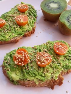 Una foto de Tostadas con aguacate, tomates cherry y sésamo
