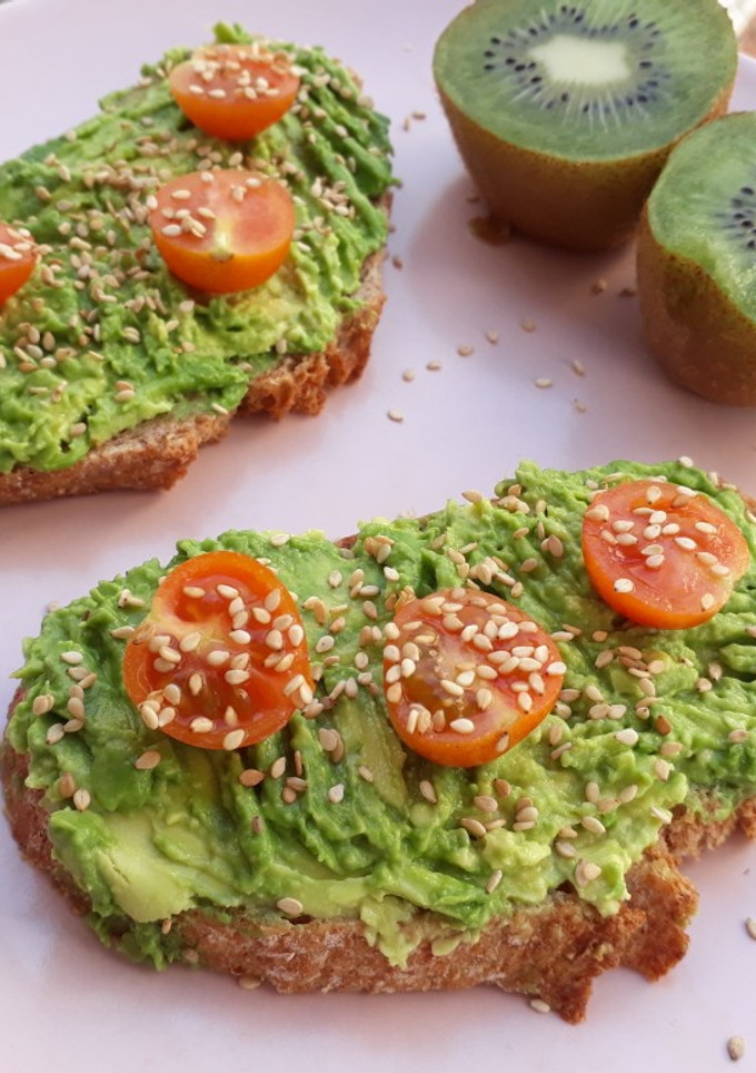 Una foto de Tostadas con aguacate, tomates cherry y sésamo