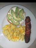 Avocado bagel with cheesy eggs and pineapple smoked sausage