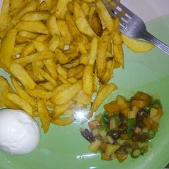 A picture of Potatoes chips  garnished with vegetable and egg.