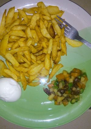 A picture of Potatoes chips  garnished with vegetable and egg.