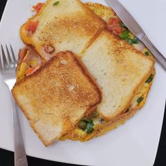 A picture of Bread sliced cheese omelette.