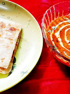 A picture of Restaurant style butter chicken with paratha.