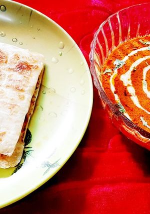 A picture of Restaurant style butter chicken with paratha.