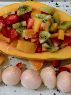 Una foto de Papaya rellena de frutas y lichis