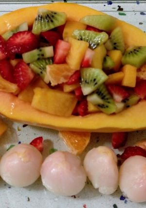 Una foto de Papaya rellena de frutas y lichis