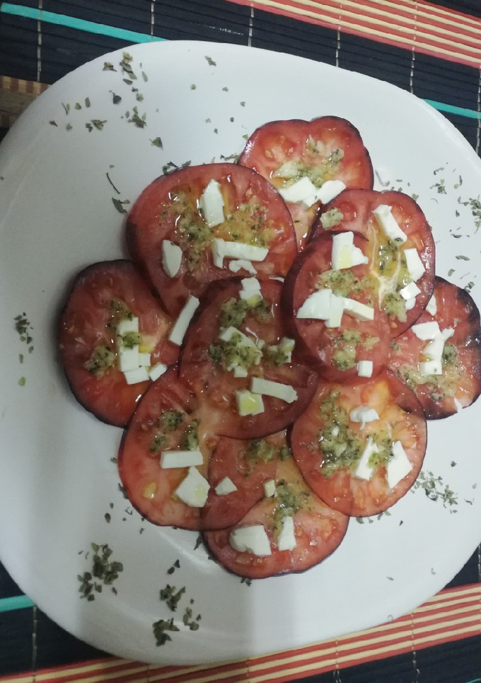 Una foto de Carpaccio de tomate Mar azul con pesto de Orégano y piñones