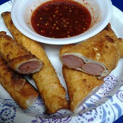 A picture of Hotdog Egg rolls with sweet and spicy sauce.
