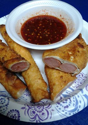 A picture of Hotdog Egg rolls with sweet and spicy sauce.