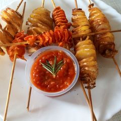A picture of Spiral potato and carrots on stick.