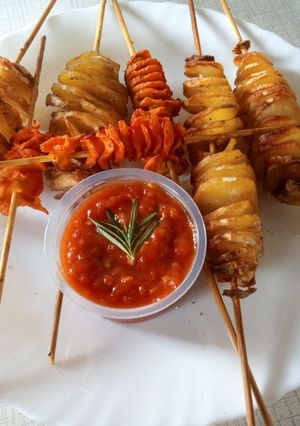 A picture of Spiral potato and carrots on stick.