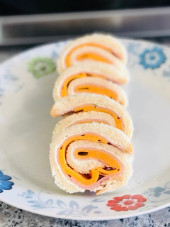 Una foto de Rollitos de pan de molde con jamón y queso